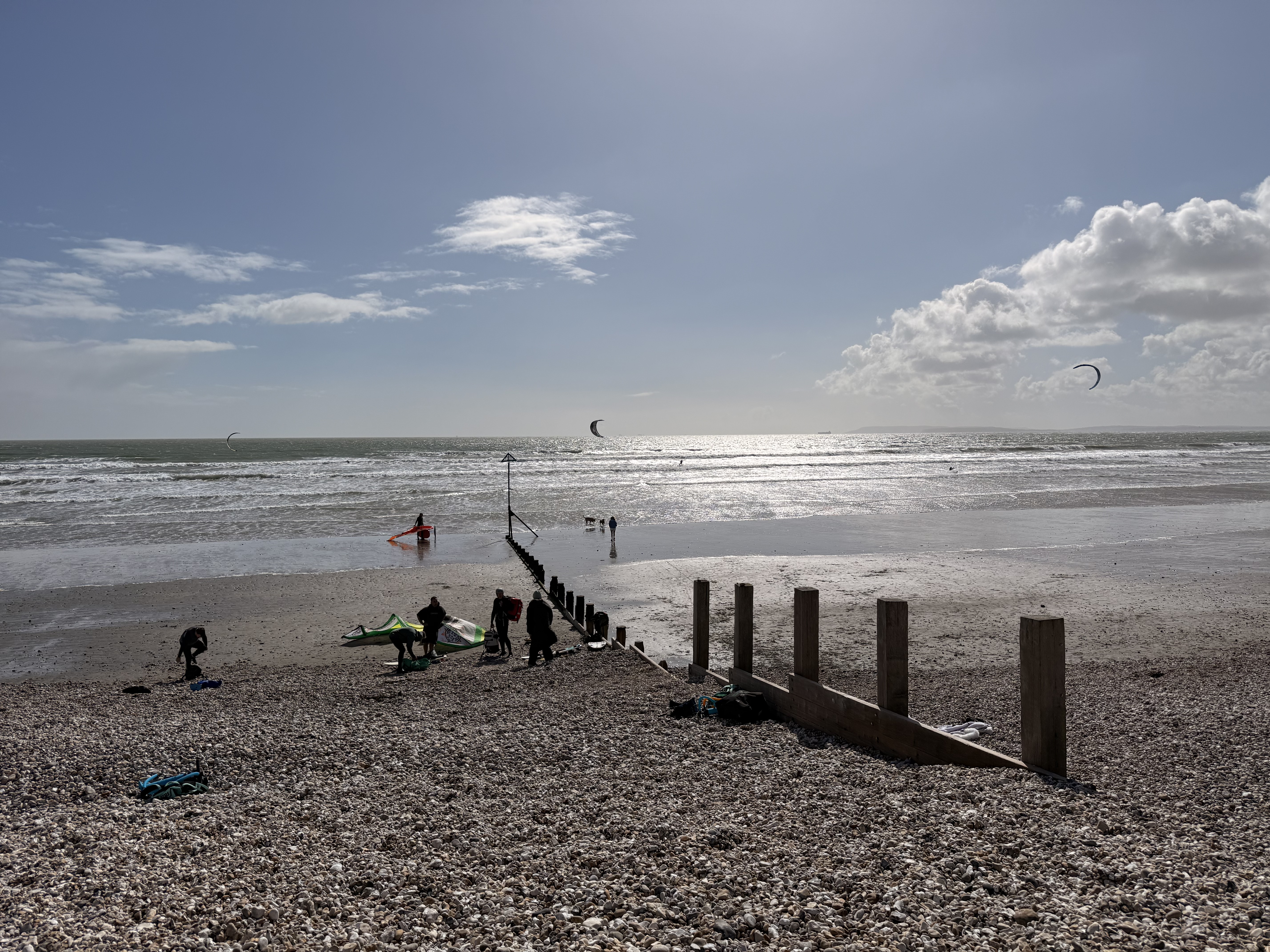 East Wittering beach with kites in the sky and groyne in the foreground