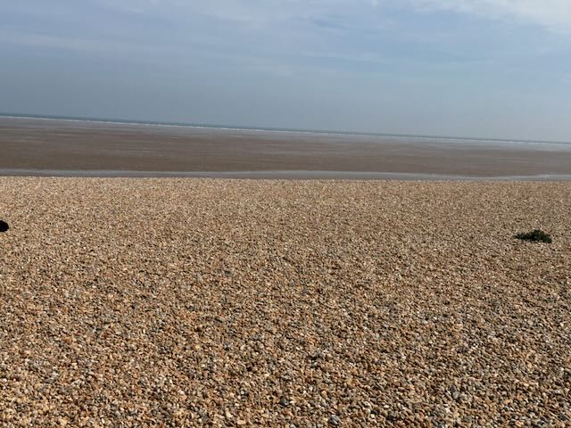 Endless shingle and wet sand at Greatstone with the water as a thin silver line on the horizon